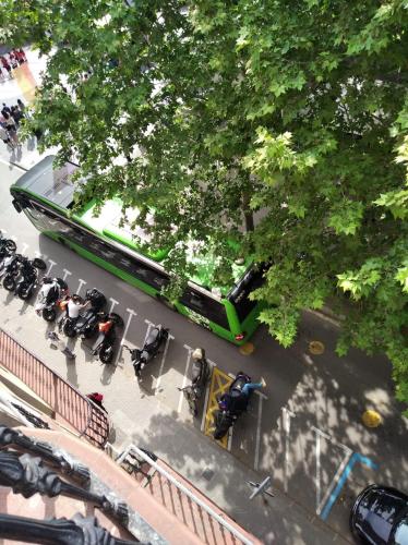 a green bus driving down a street next to trees at Pis Cèntric in Manresa