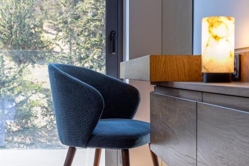 a blue chair sitting in front of a window at Neoma in Athens