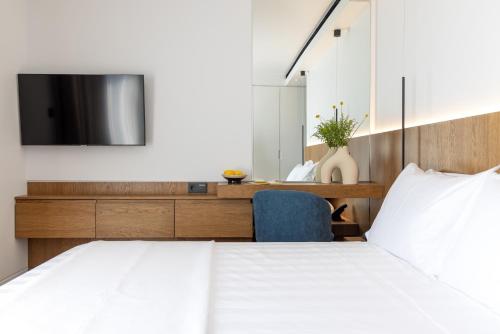 a bedroom with a bed and a tv on a wall at Neoma in Athens