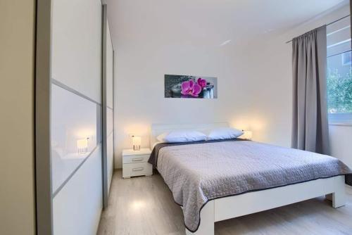 una camera da letto bianca con un letto e una finestra di Villa Emily a Medulin