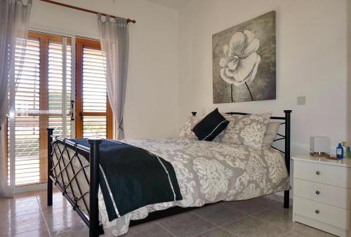 ein Schlafzimmer mit einem Bett und einem Wandgemälde in der Unterkunft Eva Gardens - Lower Peyia in Paphos City