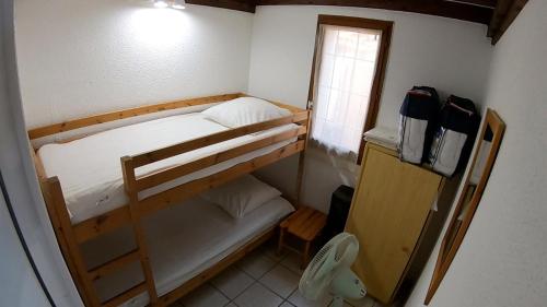Cette petite chambre comprend des lits superposés et une fenêtre. dans l'établissement Les margouillats - maisonnette à 2 pas de la plage, à Vias