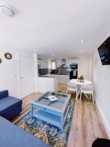 uma sala de estar com um sofá azul e uma mesa em Prosper House Apartment 6 em Norwich