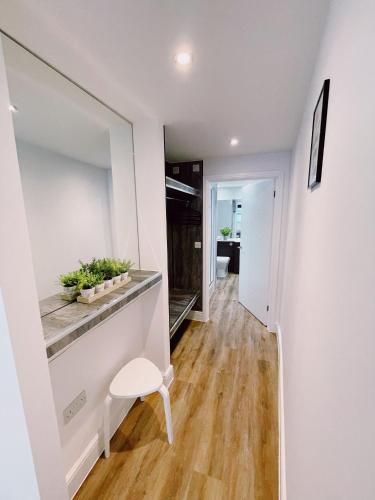a hallway with a table and a chair in a room at Prosper House Apartment 6 in Norwich