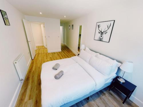 a bedroom with a white bed with two shoes on it at Prosper House Apartment 6 in Norwich