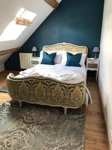 a bedroom with a large bed with blue walls at La Grange Mignonne in Teneze