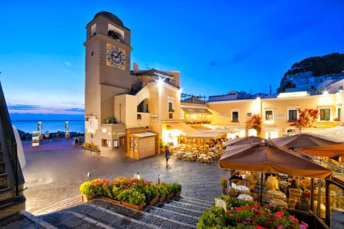 a building with a clock tower in a town at Nuida Casa Vacanze in Capri