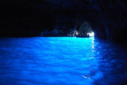a boat in the blue water in a cave at Nuida Casa Vacanze in Capri