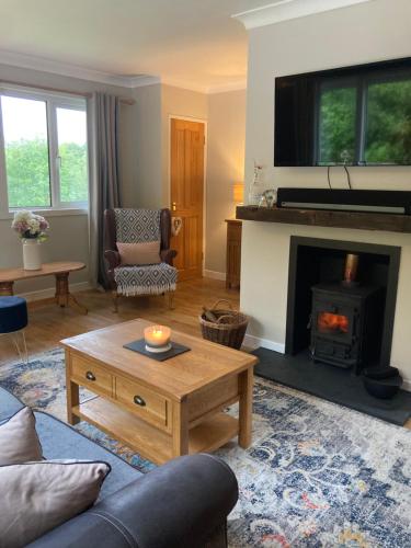 a living room with a coffee table and a fireplace at Cedar Lodge in Oban