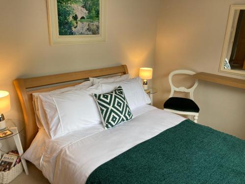 Una cama con una almohada verde y blanca. en Cedar Lodge en Oban