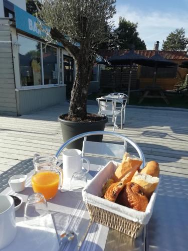- un panier de pain et de jus d'orange sur une table dans l'établissement Les chambres aux portes de l'Authie, à Fort-Mahon-Plage