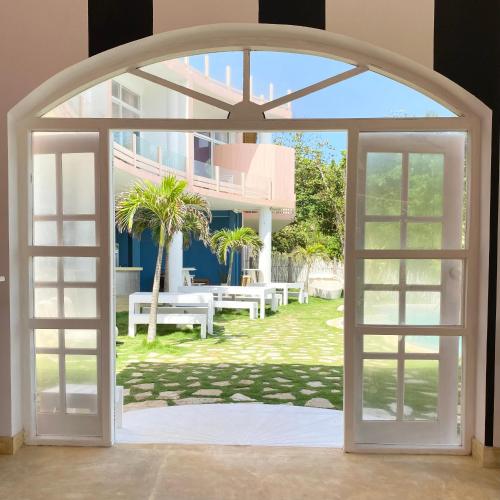 an open door leading to a yard with benches at Belika Beach in Hiriketiya