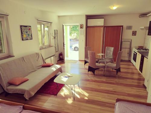 uma sala de estar com um sofá e uma mesa em Green house em Čavle