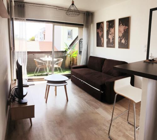 - un salon avec un canapé et une table dans l'établissement Mon appart Bougnat, à Clermont-Ferrand
