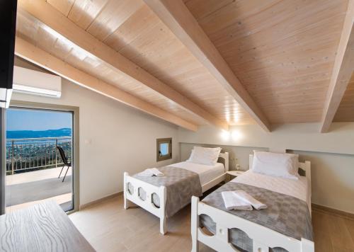 a bedroom with two beds and a balcony at Villelia View Villas 2 in Apolpaina