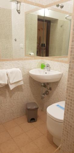 uma casa de banho com um lavatório, um WC e um espelho. em Albergo Pensione Bartoli em Castiglioncello