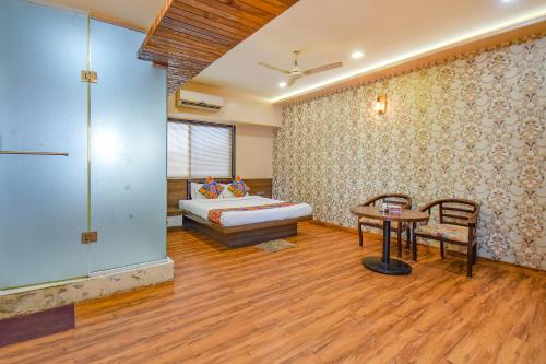 Sala de estar con cama, mesa y sidra de mesa en FabExpress Glory en Chinchwad