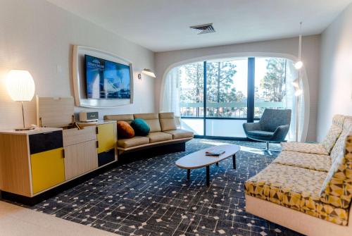 a living room with a couch and a table at Howard Johnson by Wyndham Anaheim Hotel & Water Playground in Anaheim