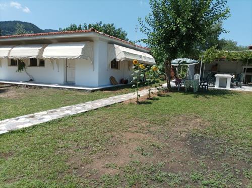 a small white house with a table and a yard at thassossweethome in Limenas