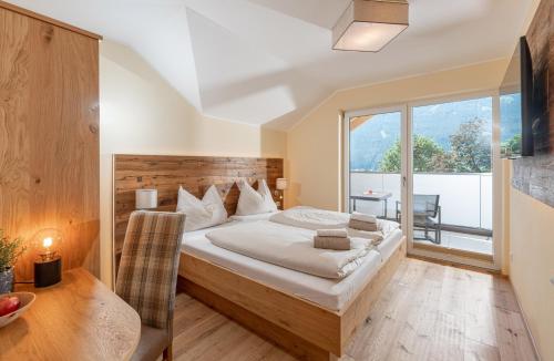 ein Schlafzimmer mit einem großen Bett und einem großen Fenster in der Unterkunft Hotel Die Metzgerstubn in Sankt Michael im Lungau