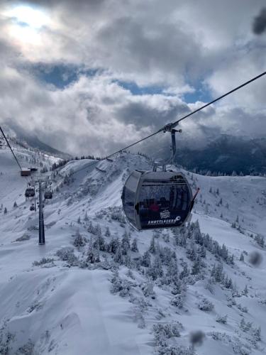 a ski lift flying over a snow covered mountain at Hotel Alpina in Kleinarl