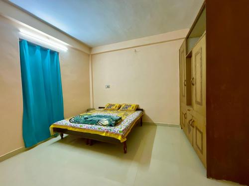a small bed in a room with a blue curtain at MOUNTAIN HOME STAY -RANG, at Reckong Peo - Kalpa, Near Goyal Motors, Way to Petrol Pump at ITBP Quarters in Kalpa