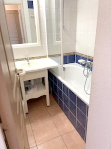 une salle de bain avec un lavabo, une baignoire et un miroir dans l'établissement Appartement avec piscine à Six-Fours-les-Plages 32 m² vue mer, à Six-Fours-les-Plages
