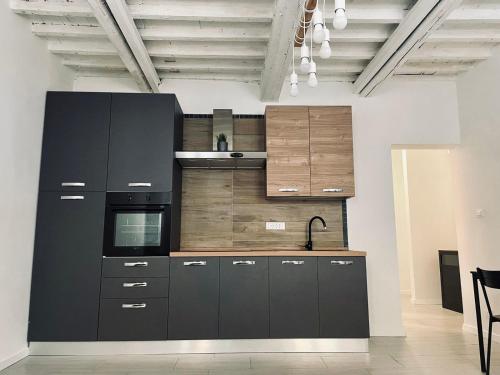 a kitchen with black cabinets and a sink at new apartment 2 minute from the port in Livorno