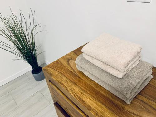 een stapel handdoeken bovenop een houten tafel bij new apartment 2 minute from the port in Livorno