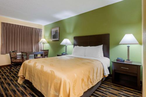 a hotel room with a large bed and a desk at Quality Inn & Suites Mt Dora North in Mount Dora
