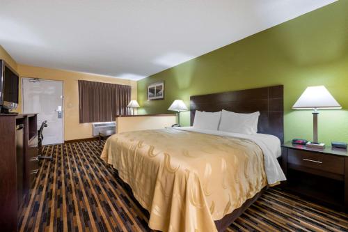 a hotel room with a large bed and green walls at Quality Inn & Suites Mt Dora North in Mount Dora