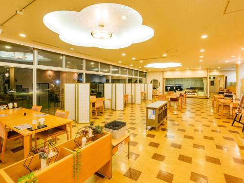a restaurant with wooden tables and chairs and a large ceiling at SPA HOTEL YUTTARIKAN in Satsumasendai