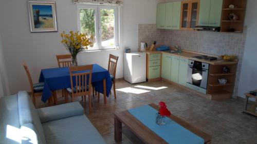 a kitchen and a living room with a table and a blue table at Apartments Barić Kučište in Kučište