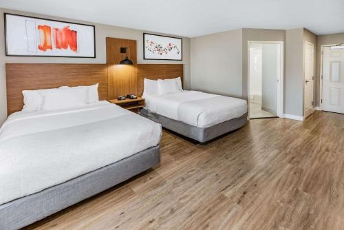 2 bedden in een hotelkamer met houten vloeren bij Hawthorn Extended Stay by Wyndham Ardmore in Ardmore