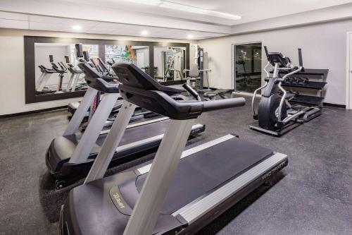 a gym with several treadmills and elliptical machines at La Quinta Inn & Suites by Wyndham Ardmore in Ardmore