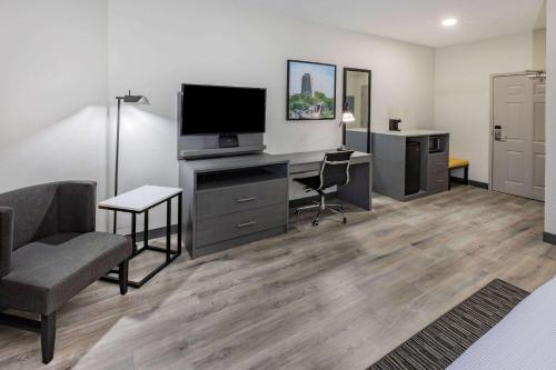 a living room with a desk with a tv and a computer at La Quinta Inn & Suites by Wyndham Ardmore in Ardmore