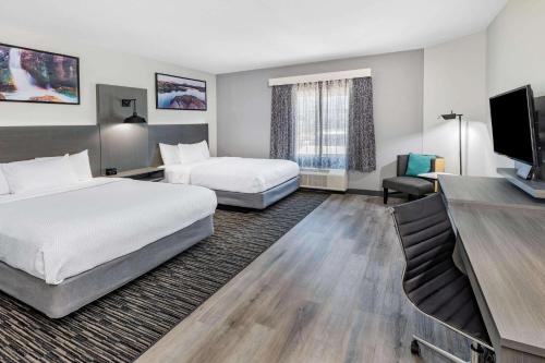 アードモアにあるLa Quinta Inn & Suites by Wyndham Ardmoreのベッド2台、薄型テレビが備わるホテルルームです。