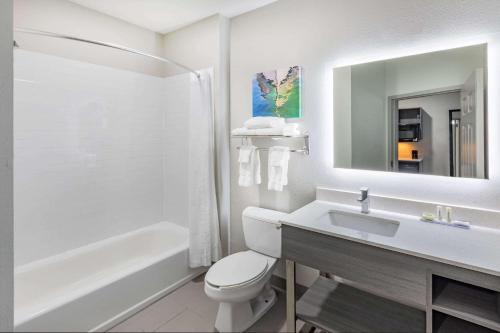 a bathroom with a toilet and a sink and a tub at La Quinta Inn & Suites by Wyndham Ardmore in Ardmore