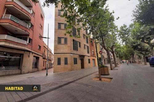 una strada vuota in una città con edifici di Hostal Rambla a Sant Boi del Llobregat