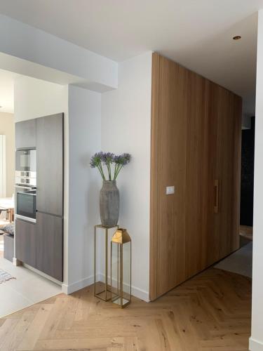 a kitchen with a large wooden door and a vase with flowers at Le Siam in Brest