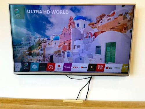 a television screen with a picture of a city at Almas Family Studio 100mbps Netflix By STAY in Nusajaya