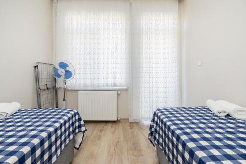 a room with two beds with blue and white checked sheets at Spacious apartment in the historical center of Bursa in Bursa
