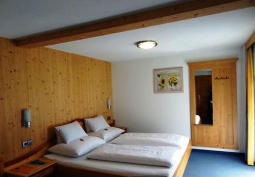 1 dormitorio con 2 camas en una habitación con paredes de madera en Gästehaus Conny, en Prägraten am Großvenediger