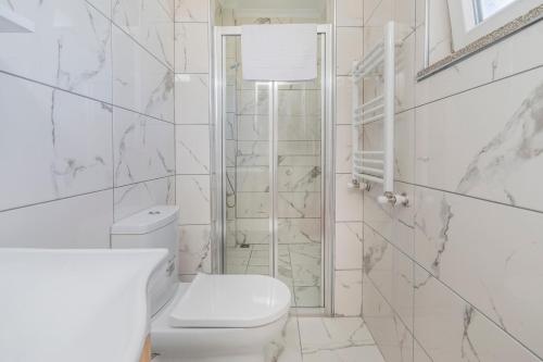 a white bathroom with a toilet and a shower at Spacious apartment in the historical center of Bursa in Bursa