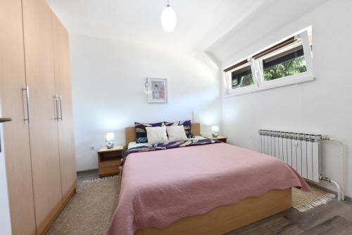 普利特維采湖的住宿－Apartman Petra，一间卧室设有一张大床和一个窗户。