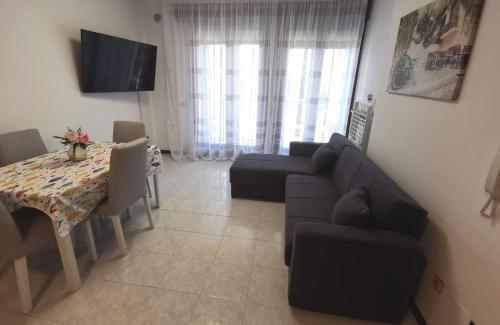 - un salon avec un canapé et une table dans l'établissement Rosolina (Paese) Apartment, à Rosolina
