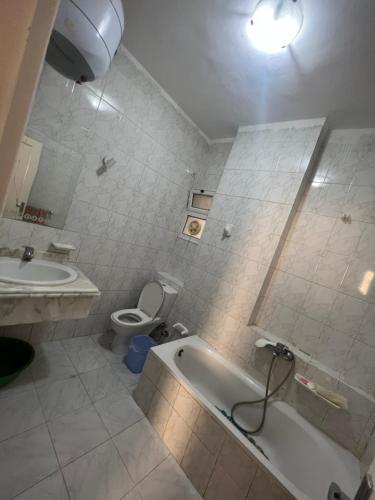 a bathroom with a tub and a toilet and a sink at Paradise Hill Compound in Hurghada