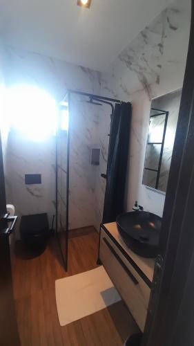 a bathroom with a black sink and a shower at Marija šimičić in Kampor