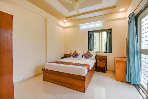 1 dormitorio con cama y ventana en FabHotel Galaxy Inn, en Pune