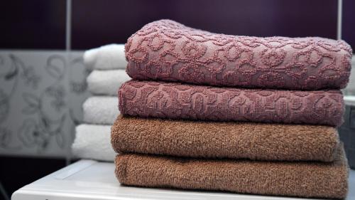 a stack of towels sitting on a counter in a bathroom at Apartman Petra in Plitvička Jezera